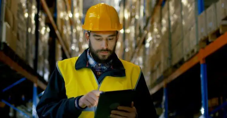 A man in a warehouse using a calculator for CBM to calculate the volumetric weight