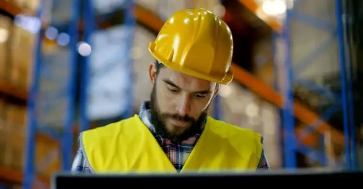 A man in a warehouse checking the output of a CBM calculator