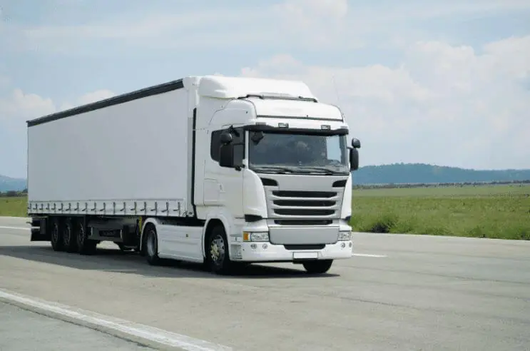 A white truck driving along the highway