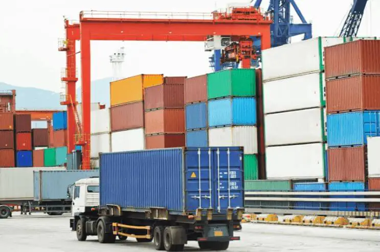 A large number of shipping containers stacked at the port, awaiting transport