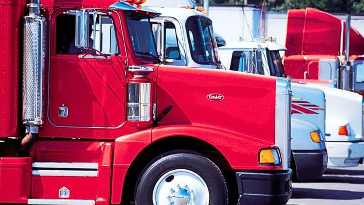 A row of red trucks lined up, ready for freight transportation.